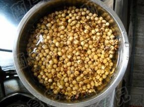 炒熟的黄豆趁热盛起倒入水中，黄豆遇水膨胀。
