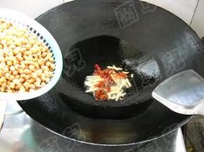 锅中油热，爆香姜丝，倒入干红椒丝。
倒入黄豆，翻炒均匀。