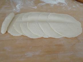 把小棒放在面皮顶部，中间用擀面杖压实（如图）