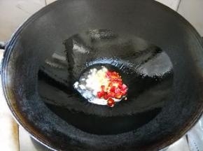 锅中油热，爆香蒜瓣和干红椒。