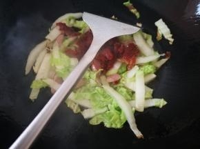 大白菜炒软后，加入脆皮肠，瘦肉，继续炒
