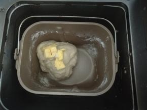 启动面包机和面程序10分钟，结束后静置5分钟加入黄油继续揉面20分钟。