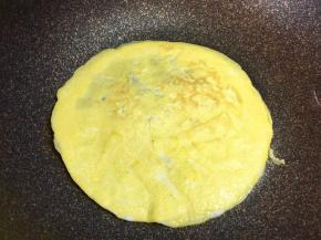 锅里倒入适量鸡蛋液，摊成圆形的蛋皮，两面煎熟，用小火慢煎，避免过焦，蛋皮不要太大，直径约16厘米。也不要太薄，避免包饭的时候破裂。煎三张。