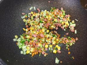 接着把火腿碎和玉米粒放入锅中翻炒。