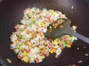 接着倒入米饭翻炒均匀。