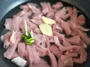 切好的里脊肉放入锅中，加入清水，没过里脊肉为佳，加入切好的姜片，葱。