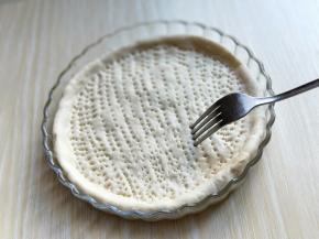 用擀面杖擀圆，放入披萨盘，用叉子叉满洞洞。如图