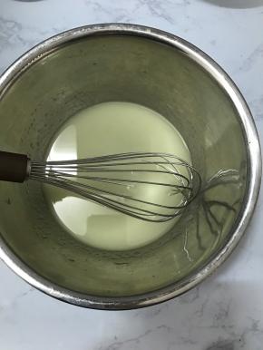 将玉米油和水倒入大碗中，用手动打蛋器搅拌均匀。