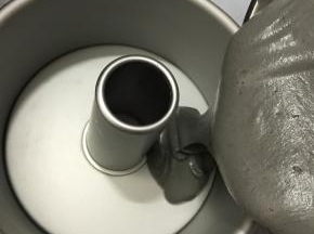 把面糊从高处倒入7寸中空模具中，轻震出大气泡。