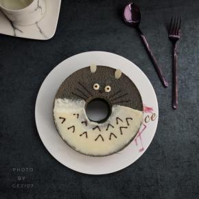 将酸奶均匀涂抹在一半戚风蛋糕上，画两个小圆圈做眼睛。将巧克力放到裱花袋中，隔水融化。剪小口，点缀眼珠，画上鼻子以及胡须，身上的小纹路。插上两片杏仁片做耳朵，可爱的龙猫就完成咯。