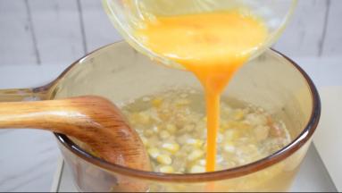 蛋液沿着锅边倒入，边倒入边搅动