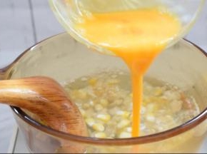 蛋液沿着锅边倒入，边倒入边搅动