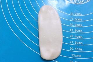 用擀面杖顺长度再次擀成椭圆形