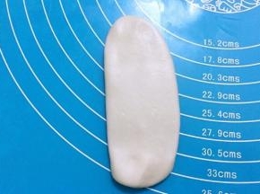 用擀面杖顺长度再次擀成椭圆形