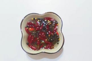 取适量花椒和干辣红椒段用清水浸泡一下；（这样就不会煸胡发黑哦）

