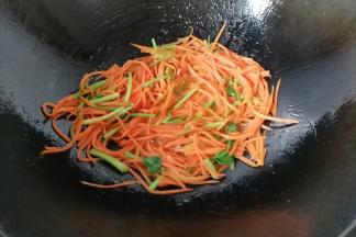 调入少许盐，点一点水炒至胡萝卜丝变软；