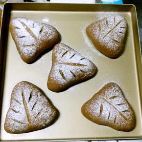 烤箱底部放盛水的烤盘，开发酵功能，将面包坯放进烤箱，发酵至两倍大，在二发好的面包坯上筛高筋粉，用刀片划痕