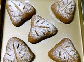 烤箱底部放盛水的烤盘，开发酵功能，将面包坯放进烤箱，发酵至两倍大，在二发好的面包坯上筛高筋粉，用刀片划痕