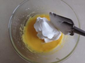 取三分之一打发好的蛋白霜放入到蛋黄糊里，从底部向上翻拌均匀。不会翻拌手法的，可以上网查看戚风蛋糕的制作视频