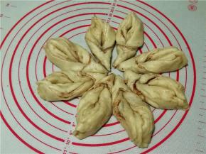 将三角的头部拉起向内弯曲穿过割口缝隙并拉直，.将三角的尾部两边捏合在一起。