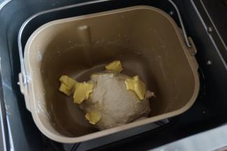 面团静置5分钟后加入切成小块的黄油