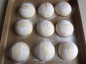 在发酵后的面包坯上，轻轻放上一个叉子，在上方用筛网过筛面粉