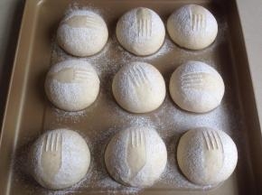 在发酵后的面包坯上，轻轻放上一个叉子，在上方用筛网过筛面粉