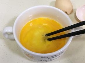 用筷子搅打鸡蛋，打出气泡，打的越散越好，然后用汤匙滤掉表面的浮泡。