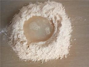 面粉倒到台面开窝，放入酵母、糖。