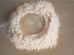 面粉倒到台面开窝，放入酵母、糖。