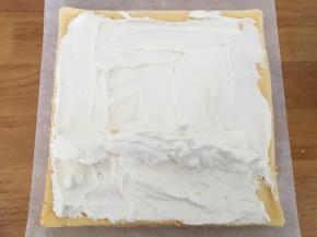 【卷蛋糕卷】蛋糕上抹上一层奶油，1/3处堆上奶油，顺势卷起