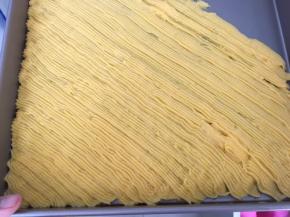 将面糊挤入烤盘内，注意每挤入一条，下一条挤入时要压着上一条的边，以免烤出来会分散开