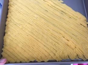 将面糊挤入烤盘内，注意每挤入一条，下一条挤入时要压着上一条的边，以免烤出来会分散开