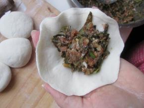 把包子皮上放上馅料。