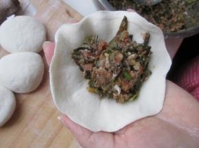 把包子皮上放上馅料。