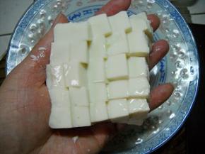 豆腐用开水冲一下，切小块。