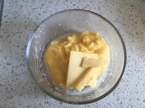 将熬好的克林姆酱趁热倒入碗中，加入黄油