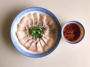 把五花肉切片，要切得波一些，平铺在盘子内，大葱叶子可以切丝放中间装饰一下