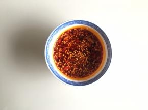 油辣椒馁加入小米辣和蒜末，加入糖、盐、熟白芝麻，和一点肉汤，搅拌均匀