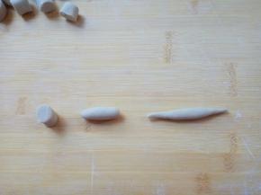 取一个面剂，按扁，搓成椭圆，再搓成俩头细，中间鼓的纺锤形。