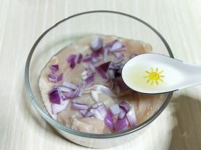 首先将鸡胸肉洗干净，从中间切开。(一块鸡胸肉切两块)洋葱切丁加入鸡胸肉中，加入料酒。