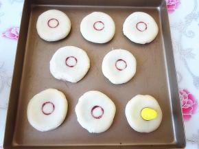 收口向下在擀成小饼，可以用水溶红曲粉，用一个小瓶盖之类的工具盖画出小圆圈