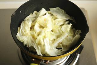 先下入白菜叶炒软。