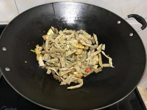 改大火放入洗净切好的竹笋，炒均匀多翻动锅铲