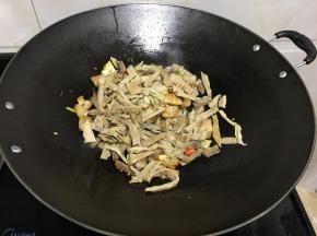 改大火放入洗净切好的竹笋，炒均匀多翻动锅铲