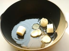 炒锅放油，爆香葱段姜片。