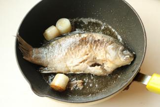 下入鲫鱼煎到鱼身两面呈焦黄。