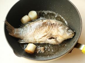 下入鲫鱼煎到鱼身两面呈焦黄。