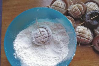 再用牙签依次从香菇从间穿过，然后放入面粉中两面都沾匀面粉；