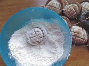 再用牙签依次从香菇从间穿过，然后放入面粉中两面都沾匀面粉；
